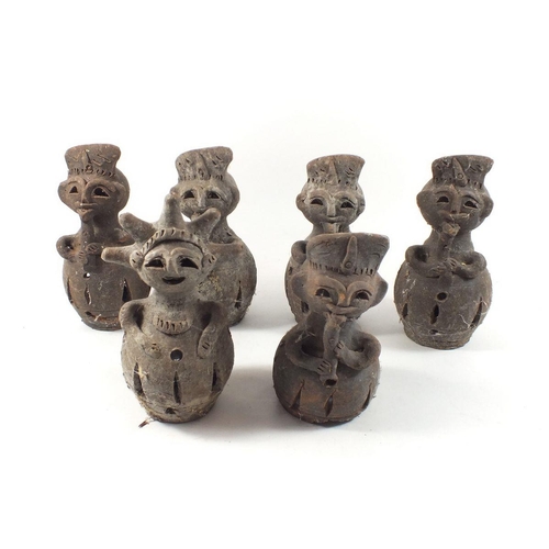 52 - An unusual set of six terracotta nightlight holders in the form of tribal figures playing pipes