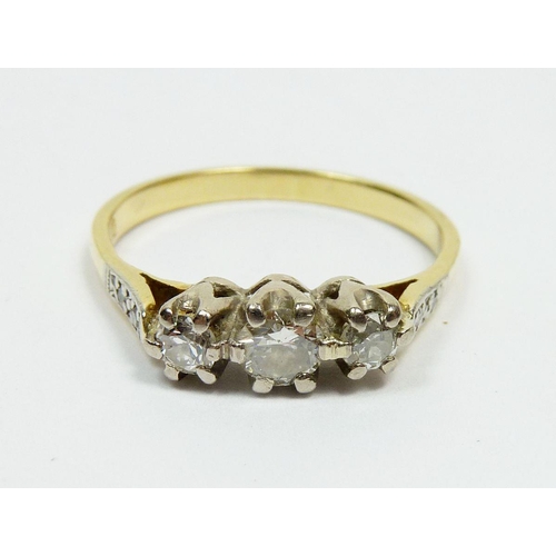293 - An 18ct gold three stone diamond ring on diamond set shoulders, cased, Size N, 3g