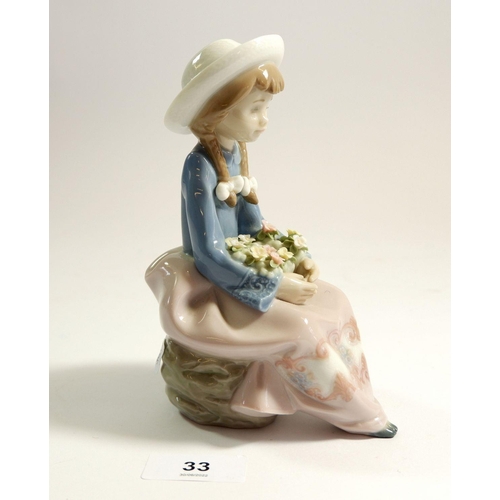 33 - A Lladro figure seated girl with flowers, 15cm tall