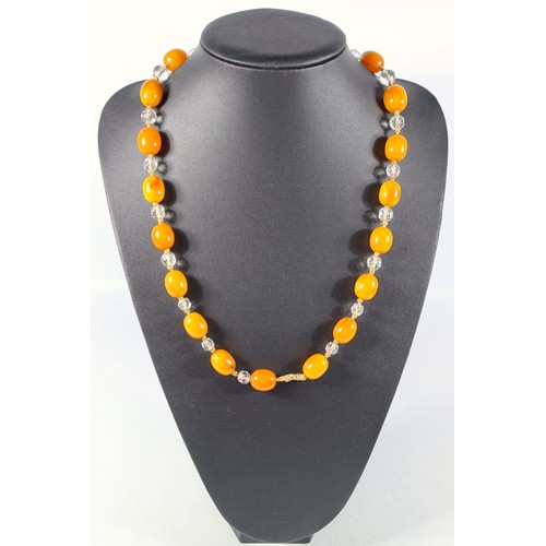 246 - 1920’s Amber and crystal necklaces, length 104 cm, largest bead 21 x 17 mm, gross weight (including ... 