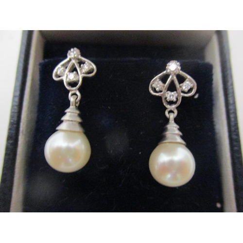 16 - A pair of 18ct white gold earrings with four diamonds and pearl drops