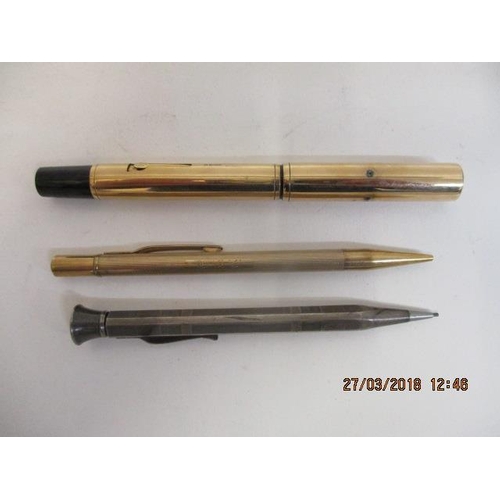25 - Three writing implements to include a 9ct gold cased propelling pencil, a silver cased hexagonal pro... 