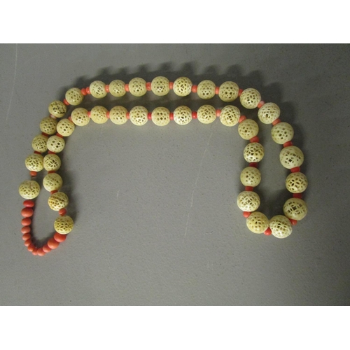262 - A Chinese Court Mandarin coral and carved ivory, beaded necklace, comprising twelve graduated coral ... 