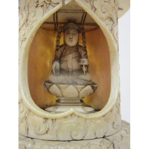 101 - An early 20th century Chinese carved ivory figure sitting cross legged in a niche, under a domed top... 