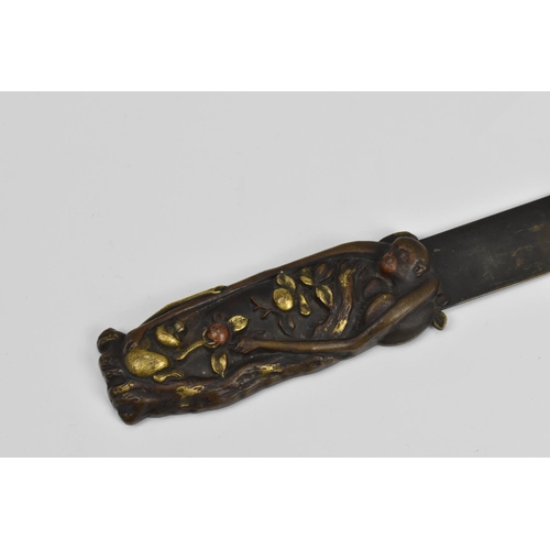 49 - A Japanese Meiji period bronze page turner, the carved handle with relief monkeys in a fruit tree to... 