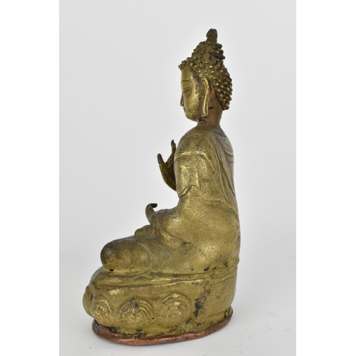 110A - A Tibetan statue of Buddha seated in Abhaya Mudra on a lotus base, base with copper cover with impre... 