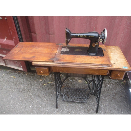 A 1920s Singer sewing machine inset in a treadle Singer tabl... | Barnebys