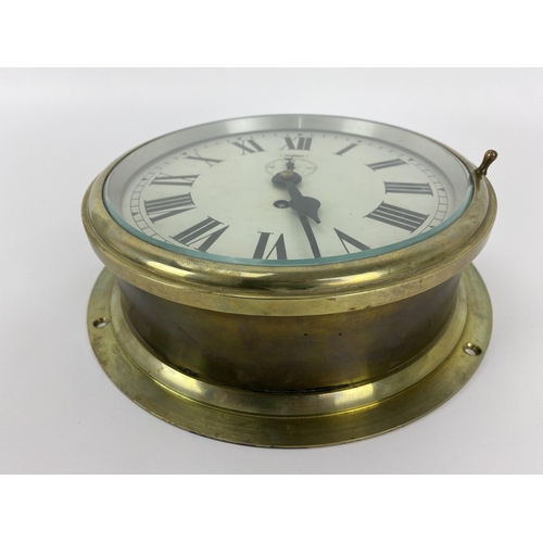 14 - An early/mid 20th century brass cased ships bulkhead clock, the 8 inch dial having Roman numerals wi... 