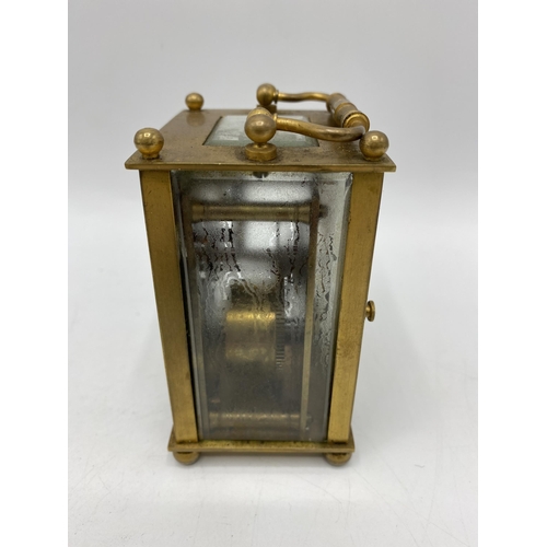 32 - An early 20th century French carriage clock having a white enamel dial with Arabic numerals and with... 