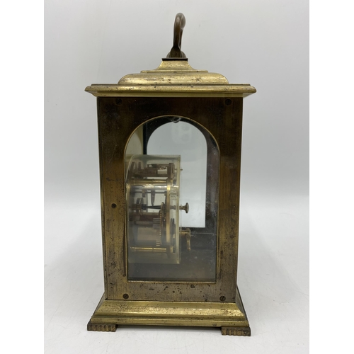 33 - A late 19th century brass cased mantle clock having a silvered dial with Roman numerals with pierced... 