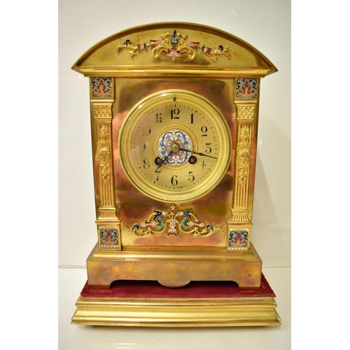 6 - An early 20th century brass mantle clock on a gilded treen stand, the arched top case with floral cl... 