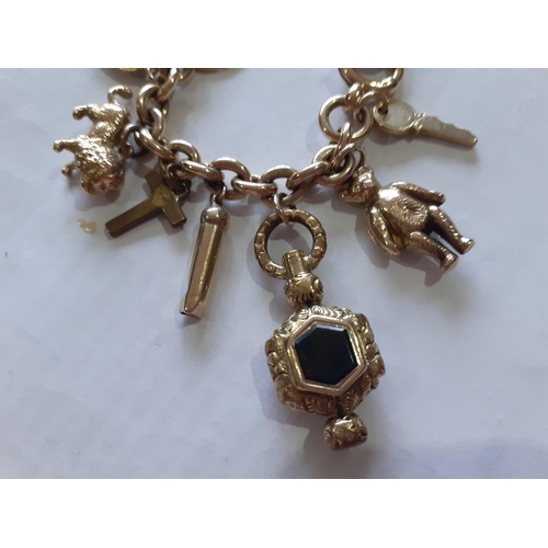24 - A 9ct gold charm bracelet having 24 yellow gold charms, mostly stamped 9ct, one unattached, total we... 