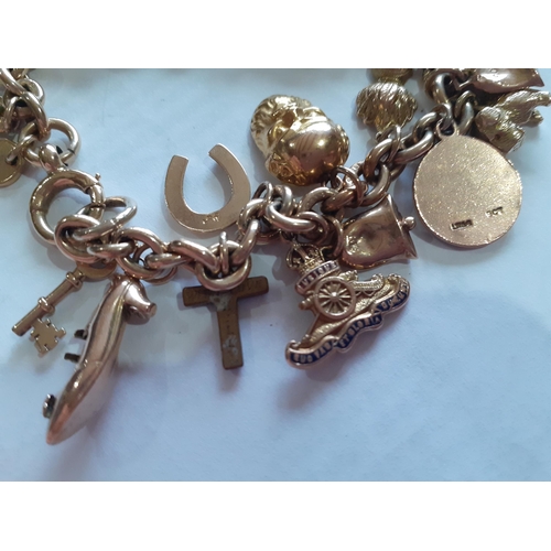 24 - A 9ct gold charm bracelet having 24 yellow gold charms, mostly stamped 9ct, one unattached, total we... 
