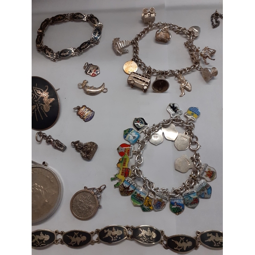 29 - A Britannia silver ingot pendant on a silver chain, 37.7g, 2 silver and white metal charm bracelets,... 