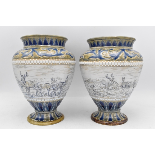 A near pair of late 19th century Doulton Lambeth stoneware vases by Hannah Barlow and assisted by Florence Barlow, of baluster form incised with a broad band of stag and deer, in shades of blue and green, the bases dated 1878 and incised with artists monograms, one 21.5 cm high x 16 cm dia the other 21 cm high x 16 cm dia
