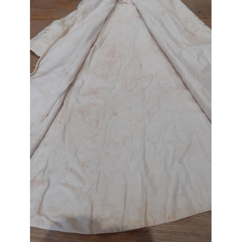 22 - An early 20th Century child's cream coloured cape with cream silk embroidered flowers and vine detai... 