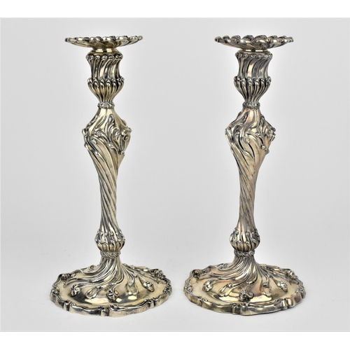 A pair of William IV silver candlesticks by Paul Storr, London 1837, in the rococo style, each of baluster form on partially domed bases, chased and engraved overall with waving scrolls, with detachable nozzle (one stuck), marked on bases, 25.5 cm high, combined weight 1458 grams