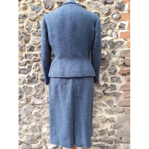 7 - Norman Hartnell- A 1960's ladies blue tweed 2-piece skirt suit having a fitted waist to the jacket, ... 