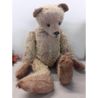 An early 20th century straw filled teddy bear with long nose, boot button eyes in the Steiff style A/F