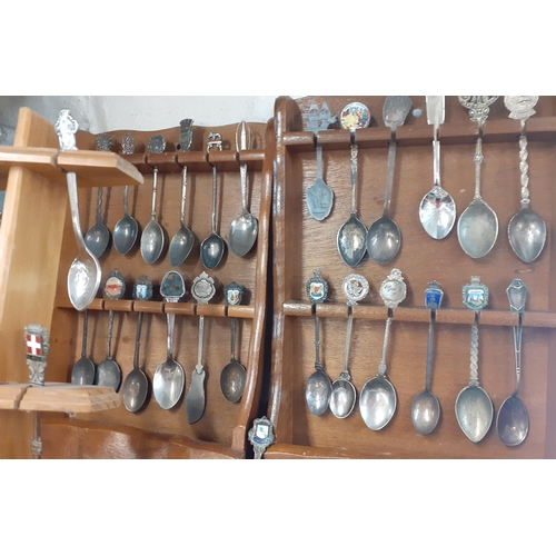 33 - Collectors teaspoons in four wall shelves to include a Rolex teaspoon and silver plated examples and... 
