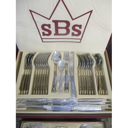 53 - A cased set of SBS stainless steel and gilded cutlery set, Location: SL