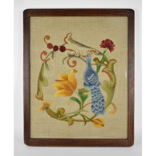 56 - An Arts & Crafts raised wool work panel decorated with a stylised peacock, tulips and Carnations, in... 