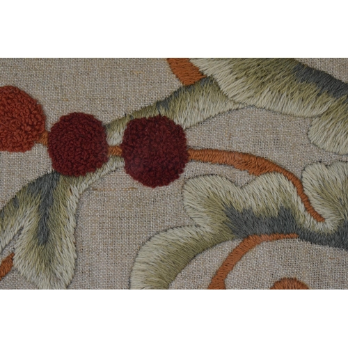 56 - An Arts & Crafts raised wool work panel decorated with a stylised peacock, tulips and Carnations, in... 