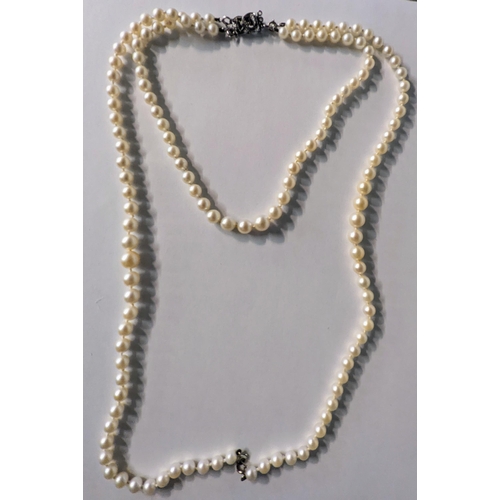 12 - A graduated pearl necklace having 9ct white gold spring rings and a white metal clasp inset with thr... 