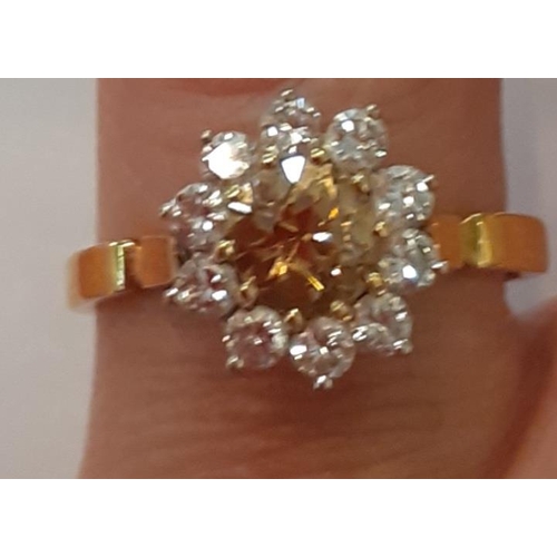 4 - An 18ct yellow and white gold eleven stone diamond cluster ring, the central champagne coloured diam... 