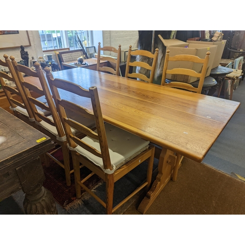 58 - An Ercol pine kitchen refectory table, on vase shaped ends, and a matching set of six ladder back ch... 