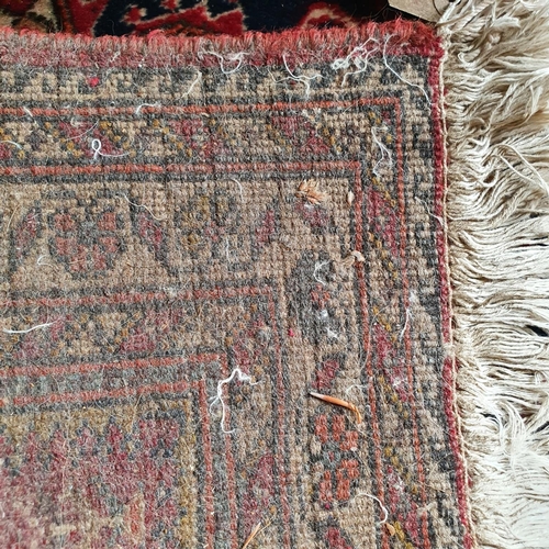 A small Persian rug, with a central lozenge on a salmon pink ground