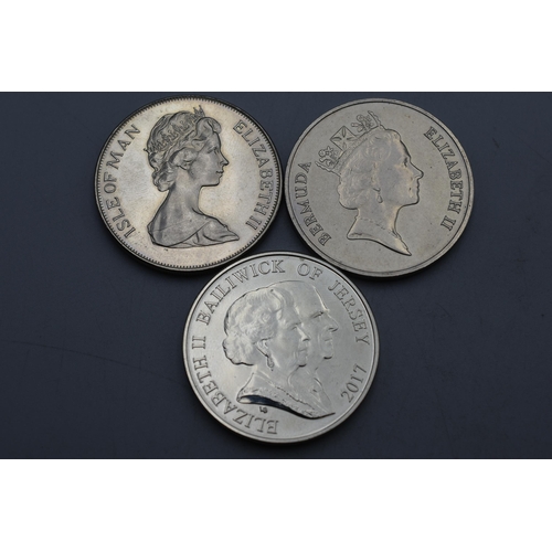 24 - Three Elizabeth II Commemorative Coins - Jersey Platinum Wedding £5, Coronation Isle of man 1978 and... 