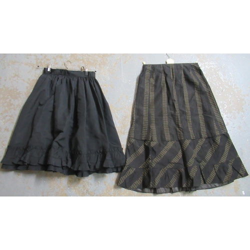39 - Two late 19th Century black skirts, one a petticoat with ruffled detail to the bottom, the other wit... 
