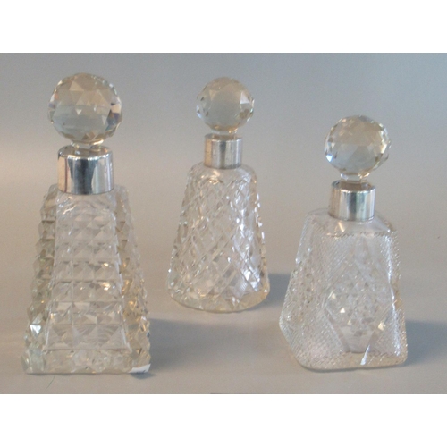 22 - Three late Victorian silver topped scent bottle with faceted stoppers and conical body. Chester 1893... 