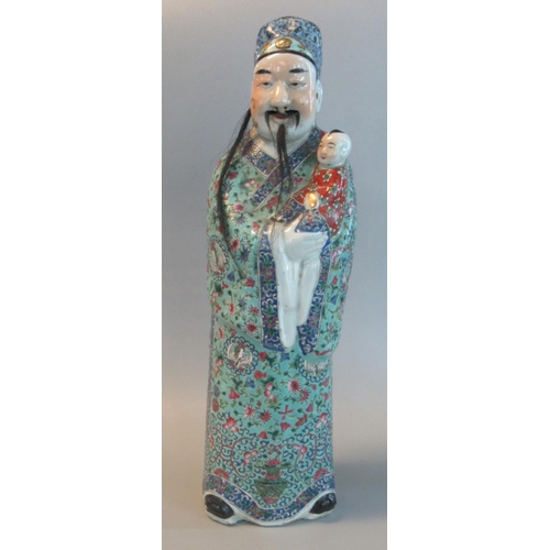 44 - Chinese porcelain standing male figure of an imortal holding a child (symbol of longevity). 20th cen... 