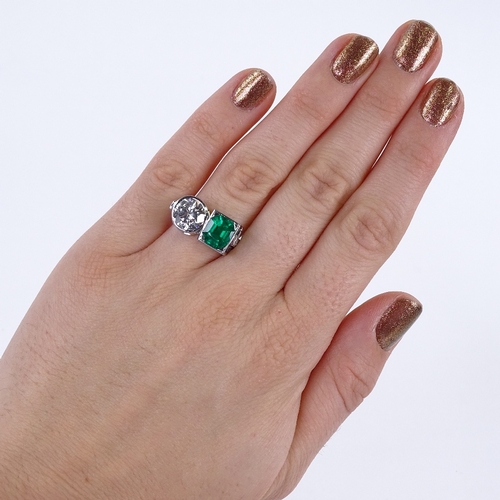 1105 - A 2-stone emerald and diamond ring, set with an octagonal emerald within a square surround and a col... 