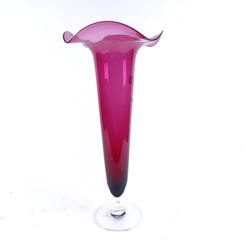 A large cranberry glass trumpet vase, height 50cm and a clea... Barnebys