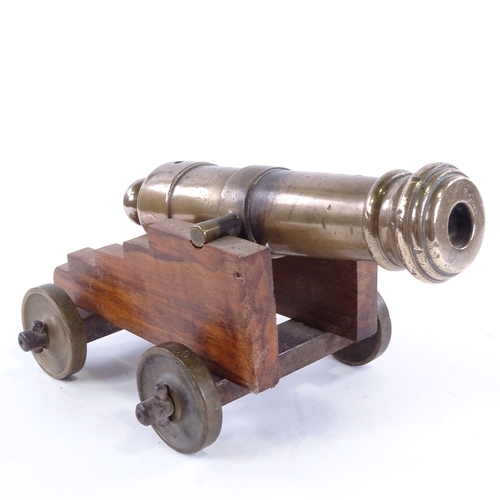 22 - A bronze barrelled table cannon, on wooden carriage with bronze wheels, barrel length 18cm, probably... 
