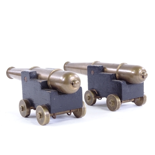 25 - A pair of bronze barrelled table cannons, on painted wood carriages with brass wheels, barrel length... 