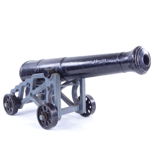 26 - A cast-iron starting cannon, on original grey painted cast-iron wheeled carriage base, barrel length... 