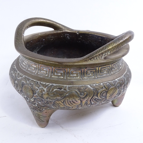 36 - A Chinese bronze 2-handled incense burner, with dragon decorated frieze raised on 3 feet, impressed ... 