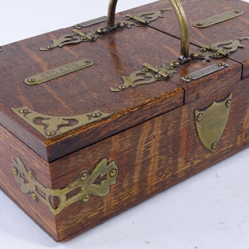 45 - A late 19th century oak cigar and cigarette box, with dual compartments, brass mounts and match stri... 