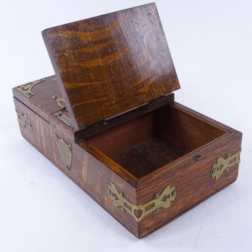 45 - A late 19th century oak cigar and cigarette box, with dual compartments, brass mounts and match stri... 
