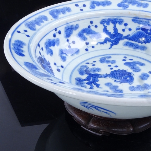 58 - A large Chinese blue and white porcelain fish design bowl and hardwood stand, diameter 30cm.
