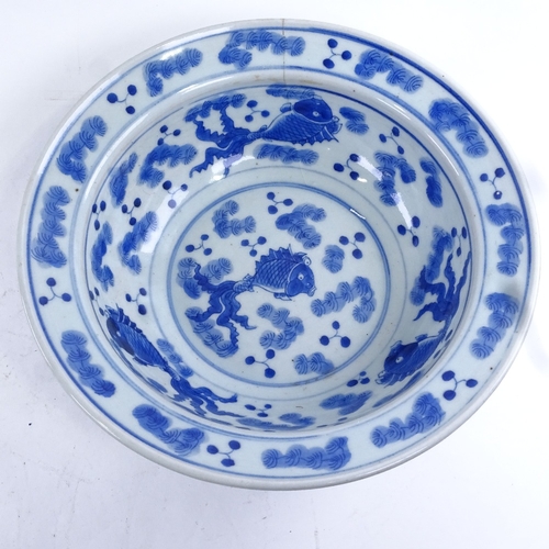 58 - A large Chinese blue and white porcelain fish design bowl and hardwood stand, diameter 30cm.