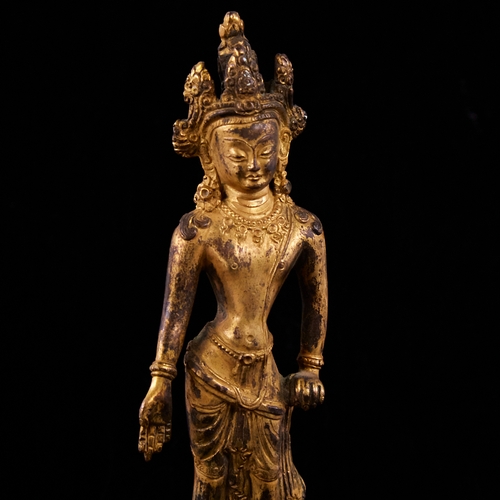12 - An Oriental gilt-bronze figure of Guanyin standing on a lotus flower plinth, height 16cm
