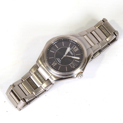 16 - SEIKO - a titanium Solar quartz wristwatch, ref. V145-0BA0, black dial with steel baton hour markers... 