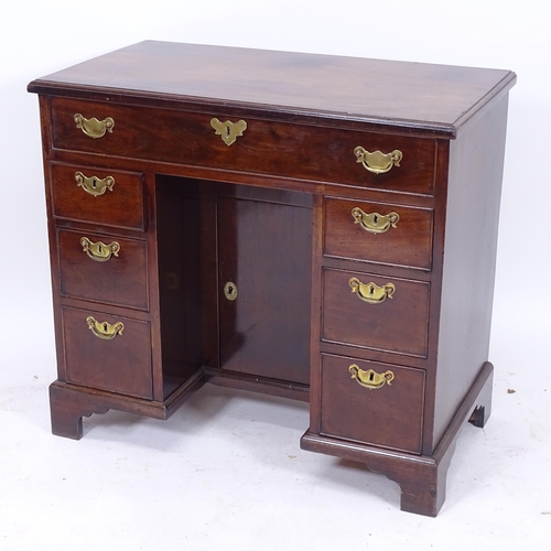 2053 - A George III mahogany kneehole writing desk of small size, with recessed alcove cupboard, and fitted... 