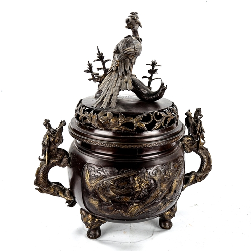 1129 - A large Chinese patinated bronze incense burner, with exotic bird finial, parcel gilt relief cast pa... 