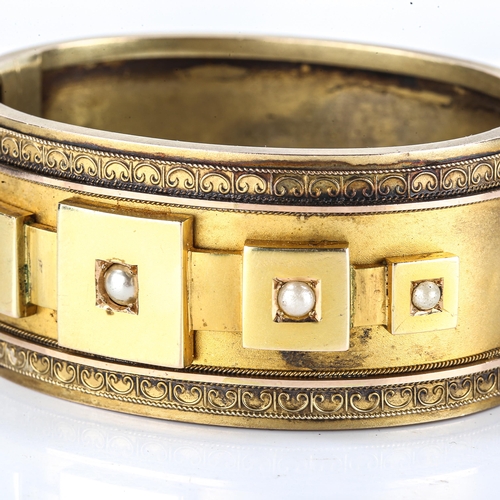101 - A late Victorian Etruscan Revival hinged bangle, unmarked yellow metal settings, set with split pear... 